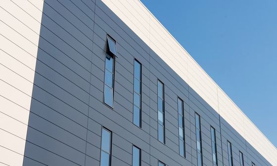 Almacén de estructura de acero industrial con puerta enrollable y sistema de revestimiento de lana de roca ignífuga